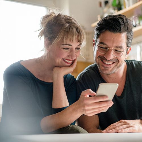 Eine Frau und ein Mann schauen gemeinsam auf ein Handy